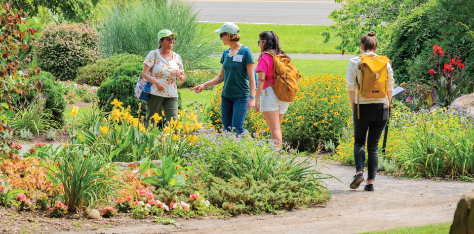 Participants of the AHS National Children and Youth Garden Symposium on a field trip to a local garden, exploring and learning about innovative gardening practices.