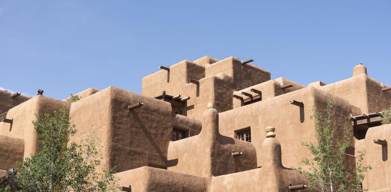 Adobe architecture of Santa Fe, featuring traditional earth-colored buildings made from sun-dried earth and straw, contrasting against the deep blue sky, reflect the city's rich cultural heritage and unique architectural style.