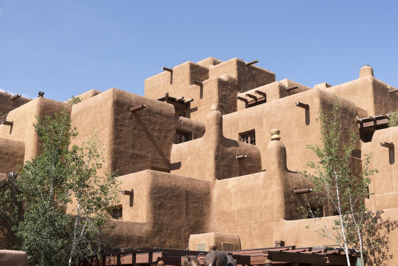 Adobe architecture of Santa Fe, featuring traditional earth-colored buildings made from sun-dried earth and straw, contrasting against the deep blue sky, reflect the city's rich cultural heritage and unique architectural style.