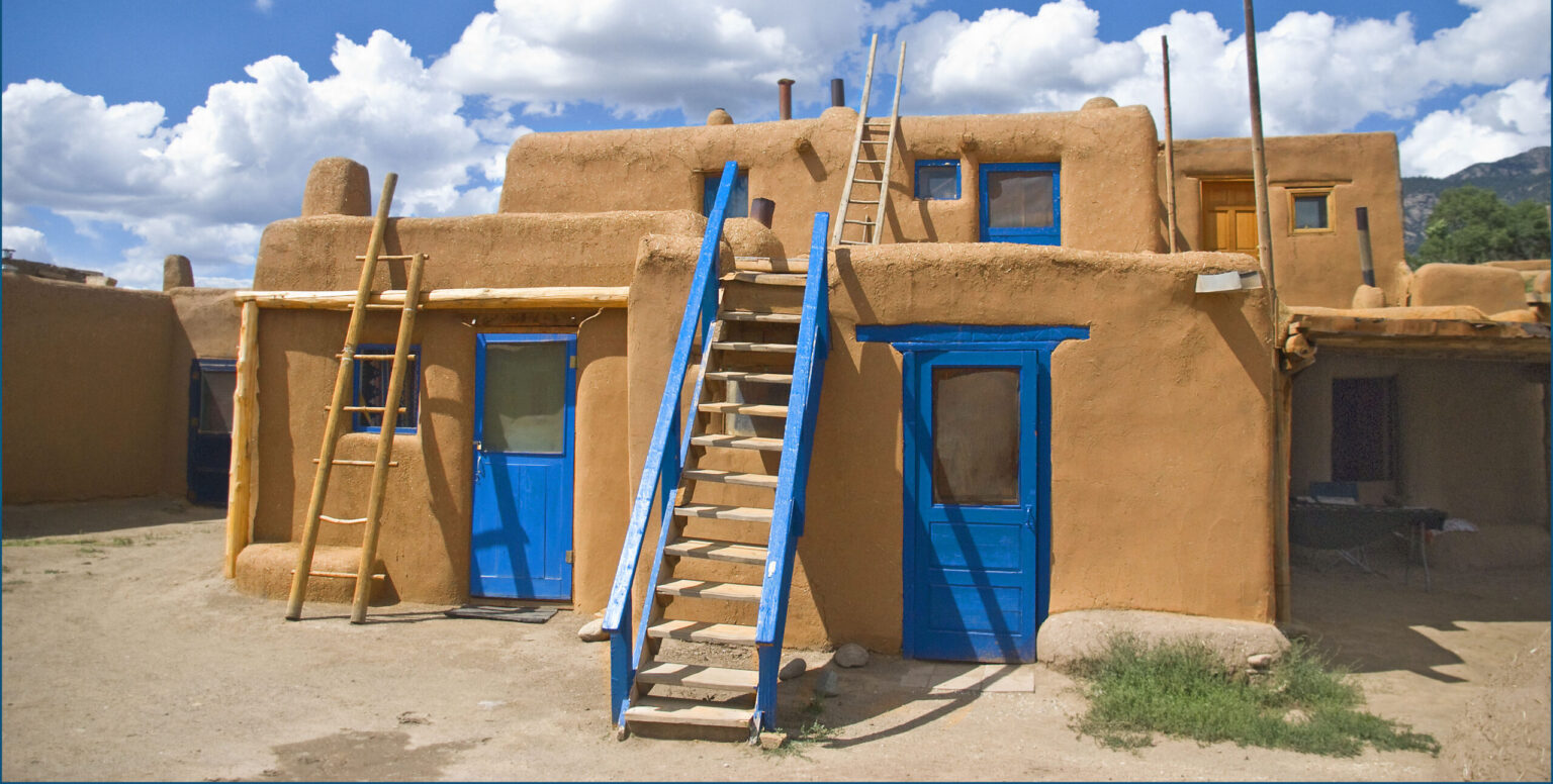 Iconic blue doors of Taos Pueblo, New Mexico, painted in the distinctive 'Taos Blue' color, which is often associated with protection from evil spirits and is a long-standing tradition in the pueblo.