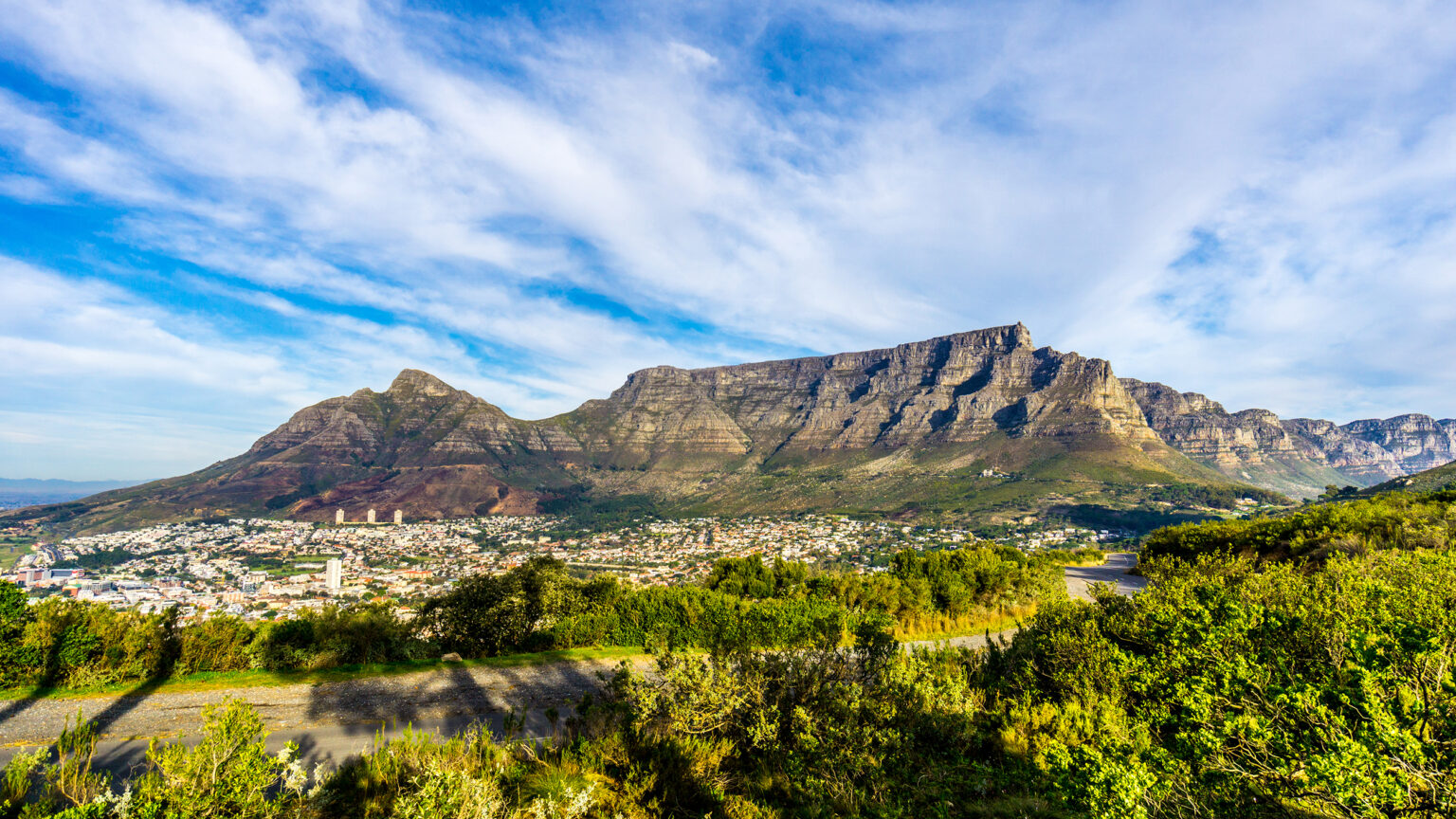 Sun setting over Cape Town, Table Mountain, Devils Peak, Lions Head and the Twelve Apostles. Viewed from the road to Signal Hill at Cape Town, South Africa