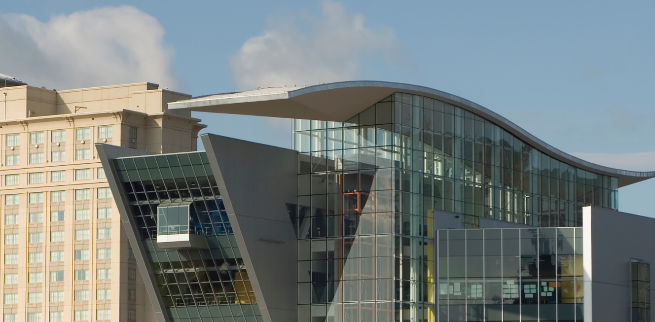 The Connecticut Science Center building features transparent glass, reflective metal panels, photovoltaic panels, and a prominent LED screen.