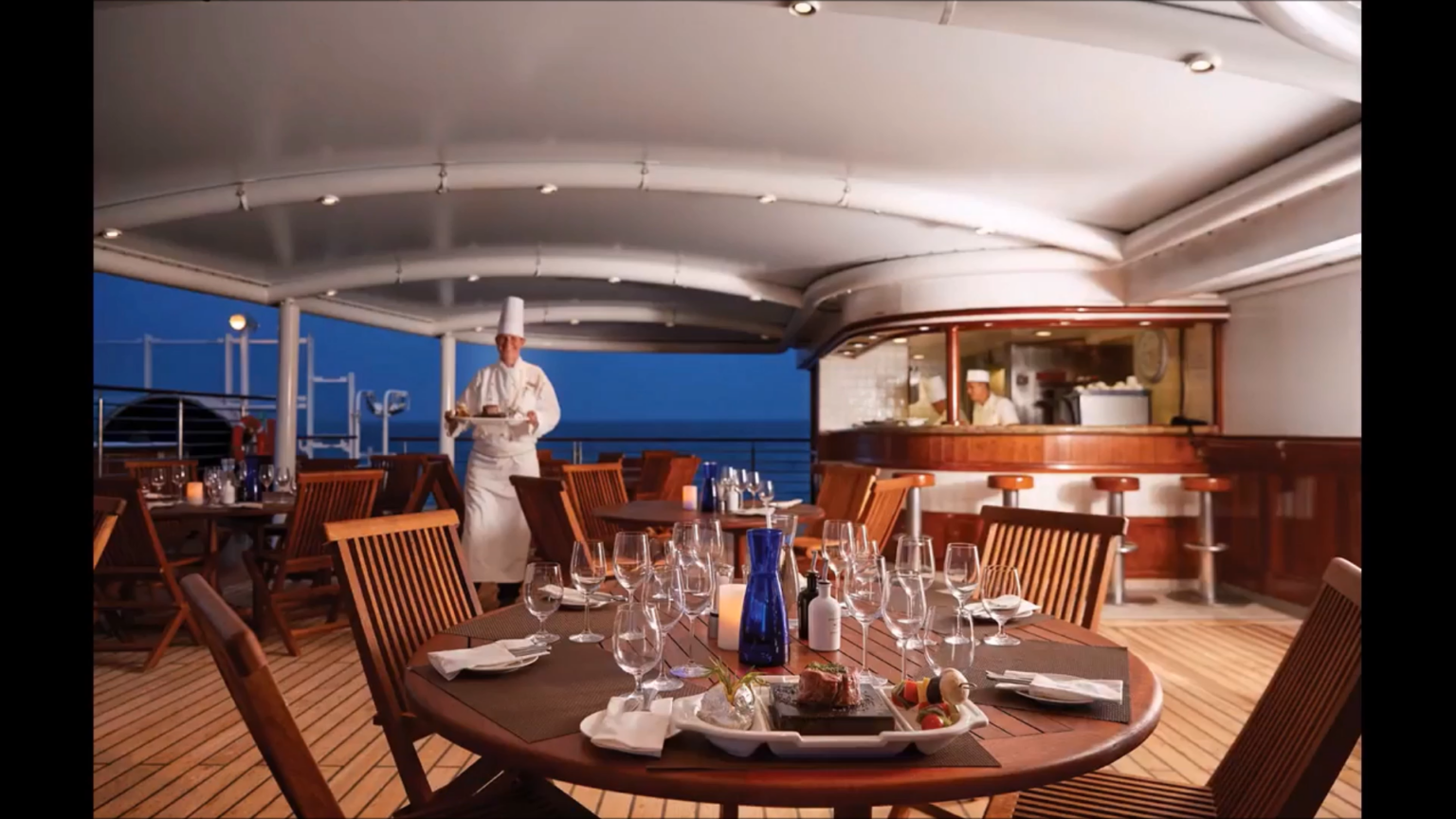 a chef brings an immaculate dish to the dinner table aboard Exploris One