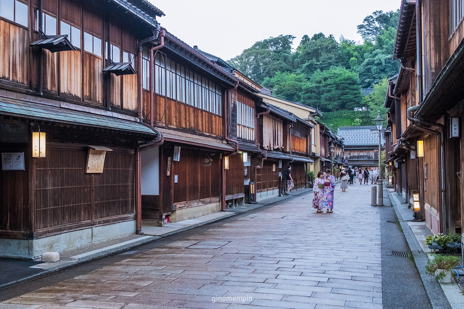 a brick street consisting of rows of teahouses and two women dressed in kimonos in the Higashi Chaya District