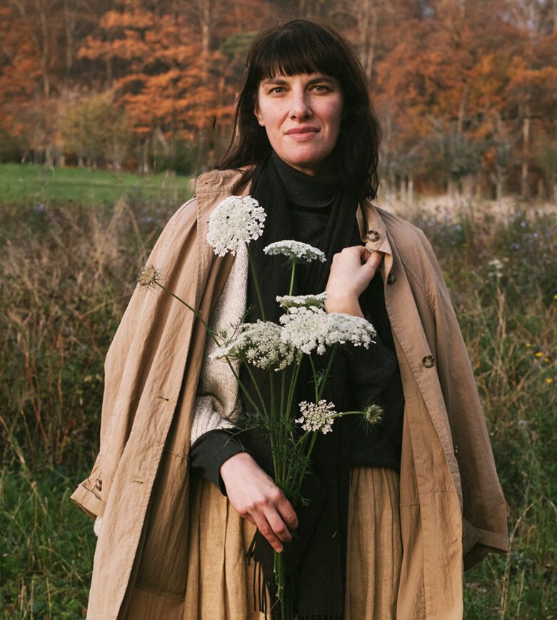 Amy Merrick, poised with flowers in an autumn outdoor setting, won the Frances Jones Poetker Award, produced by the American Horticultural Society.