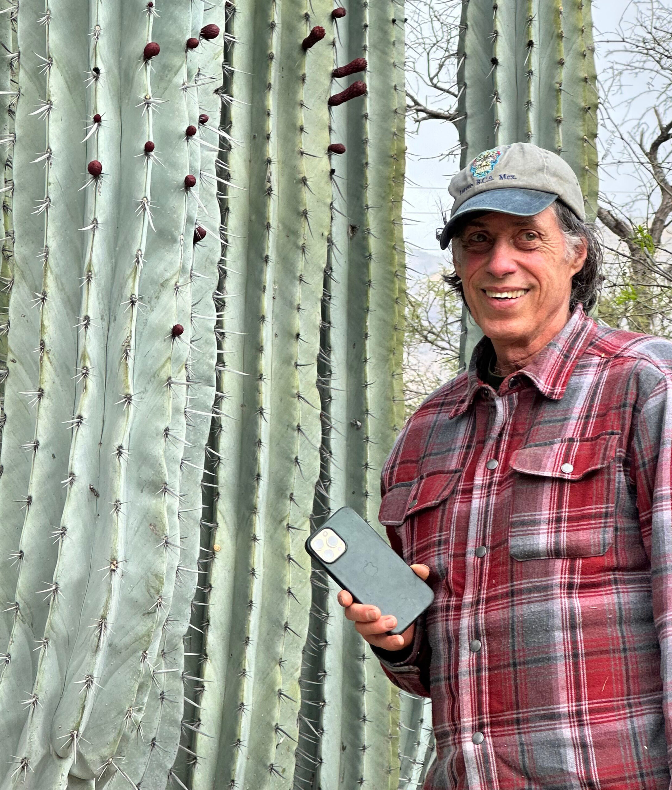 Brian Kemble next to a large cactus. He is the winner of the 2025 Liberty Hyde Bailey Award, part of the American Horticultural Society's Great American Gardeners Awards.