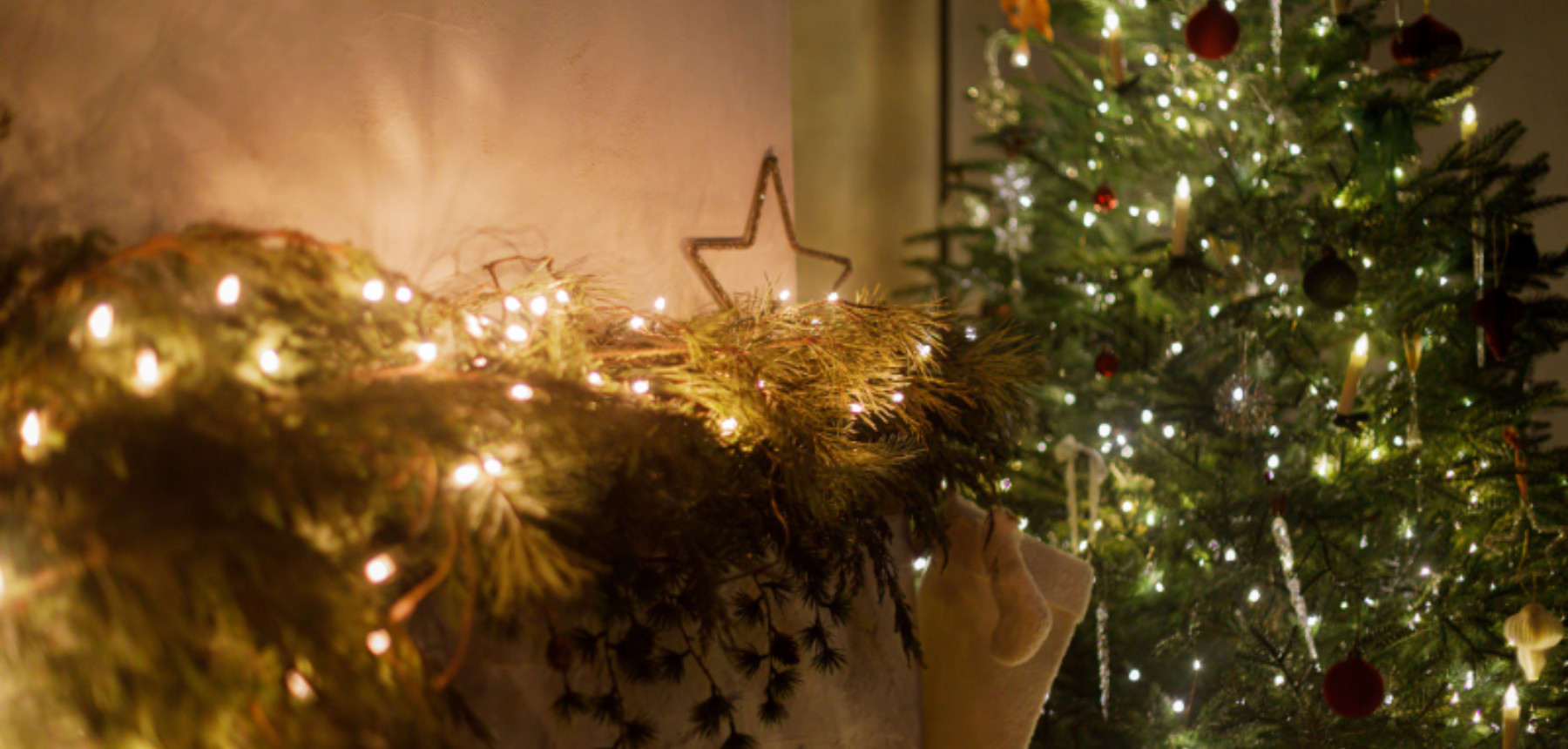 Fireplace mantel with warm holiday lights and greenery