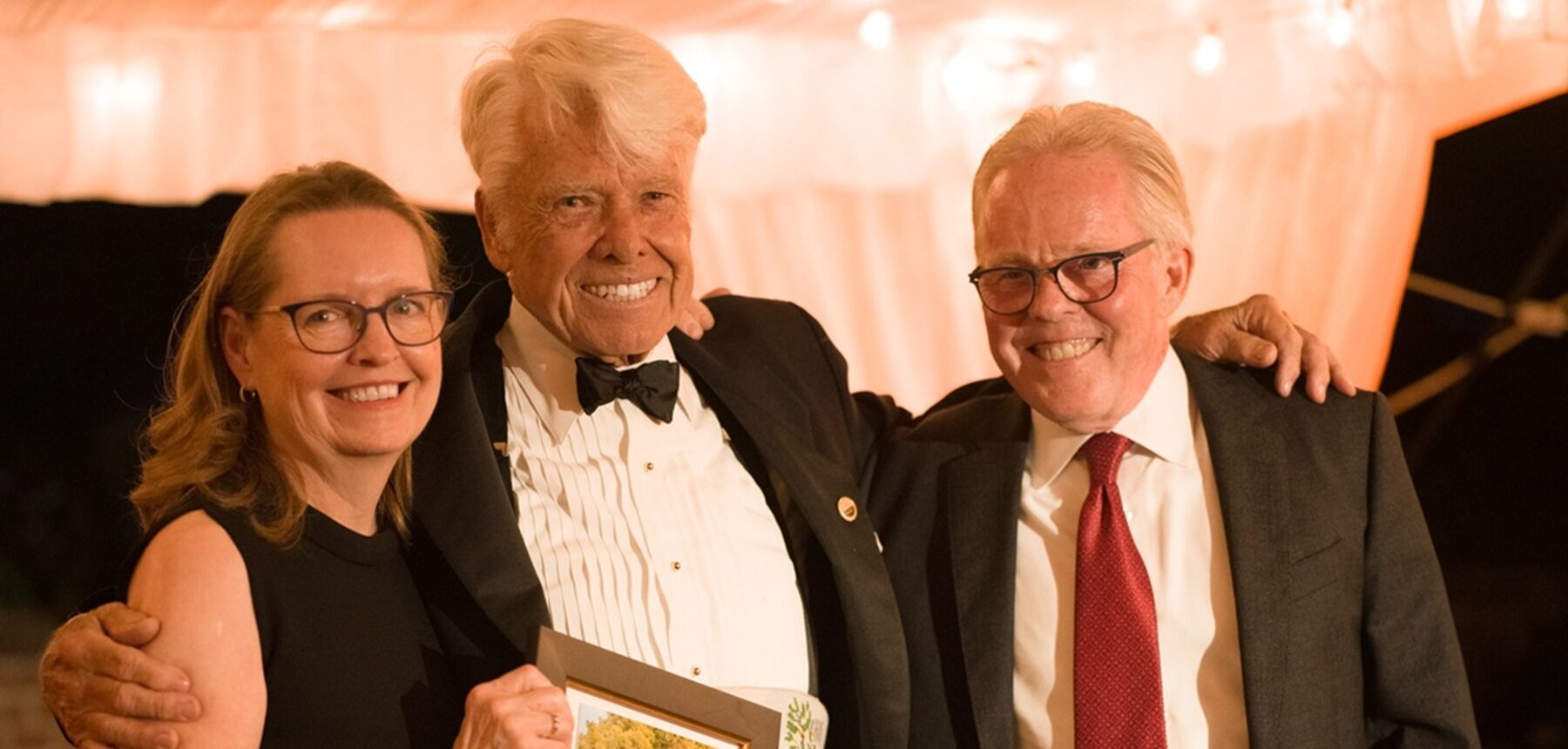 Three people face the camera smiling