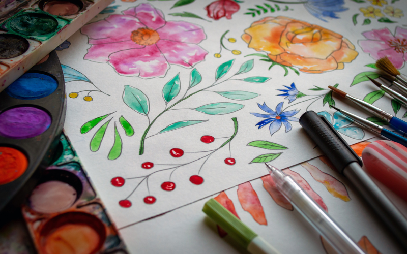 Colorful illustration of flowers, leaves, and berries, along with art supplies near the edges.